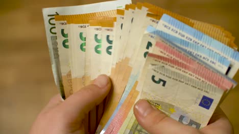 Womans-hands-counting-stack-of-euro-cash-money