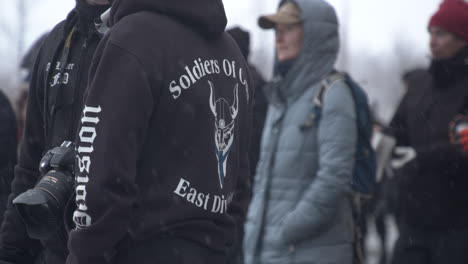 Shot-of-two-people-wearing-Soldiers-of-Odin-addending-the-Helsinki-Covid-19-protests,-cold-snowy-weather