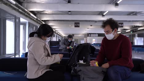 Paar-Mit-Gesichtsmasken-Sitzt-Während-Der-Koronakrise-Am-Flughafen