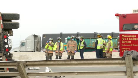 Firefighter-Workers-Relaxing-Next-To-Overturned-Truck