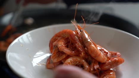 cook-removing-fried-prawns-from-the-heat-during-the-preparation-of-fideua