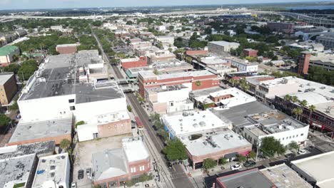 aerial-arching-over-East-8th-Avenue-in-Ybor-City,-in-Tampa,-Florida,-arch-ends-with-a-distant-view-of-Port-Tampa-and-the-Ybor-Channel