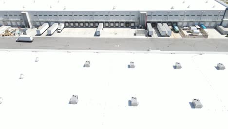 rail-cam-aerial-of-brand-new-industrial-distribution-center-roof-looking-into-the-truck-dock