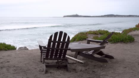 Beautiful-view-of-the-ocean,-two-wooden-chairs-and-table-by-the-bay