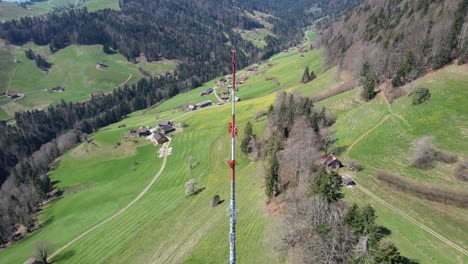 Aerial-tilt-up-and-fly-over-a-huge-red-metal-antenna-tower-in-Europe