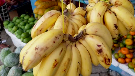 A-fresh-bunch-of-yellow-bananas-hanging-on-a-stall-at-the-local-fruit-and-vegetable-market-in-Timor-Leste,-South-East-Asia