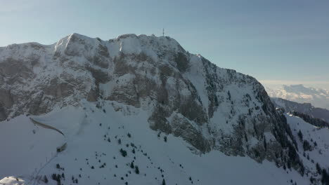 Drohne-Fliegt-Auf-Den-Fernen-Funkturm-Auf-Dem-Schneebedeckten-Berggipfel-Zu