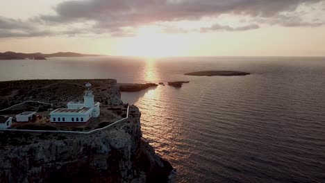 Sunset-At-Cape-Cavalleria-Lighthouse-In-Menorca,-Spain---aerial-drone-shot