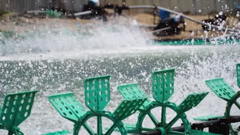 Water-Splashing-From-Green-Paddle-Wheel-Aerators-On-A-Shrimp-Farm-At-Son-Hai,-Vietnam