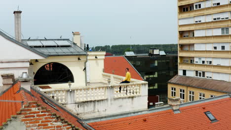 Mann-Sitzt-Auf-Der-Dachterrasse-Eines-Gebäudes-Und-Trinkt-Bier-In-Der-Stadt-Vukovar,-Kroatien