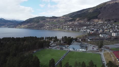 Two-soccer-fields,-swimming-arena-and-racetrack-at-Voss-Norway---Vangswater-lake-in-the-background