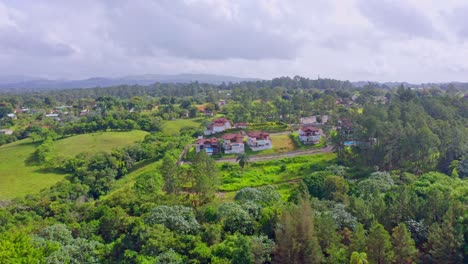 Luftflug-Zeigt-Eine-Herrliche-Grüne-Landschaft-Mit-Bäumen,-Feldern-Und-Einem-Kleinen-Dorf-In-Jarabacoa