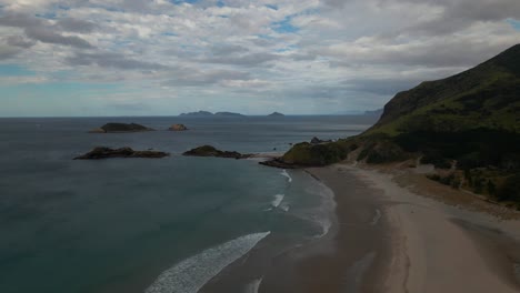 Beautiful-Whangarei-Heads-Ocean-Beach-in-New-Zealand-on-a-cloudy-day--aerial