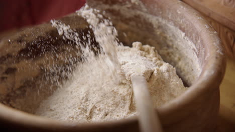 BAKING---Hand-sprinkling-flour-on-batter,-sourdough-bread-baking,-slow-motion