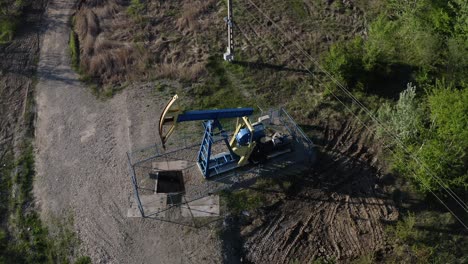 Aerial-View-Of-Oil-Pump-Equipment-Beside-The-Highway-Near-Campina,-Romania