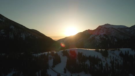 Drohne-über-Leuchtendem-Sonnenuntergang-Auf-Schneebedeckten-Berggipfeln-In-Brighton,-Utah