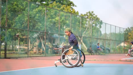 Yogyakarta,-Indonesien---2.-Mai-2021:-Asiatischer-Mann-Im-Rollstuhl-Spielt-Tennis-Auf-Dem-Platz