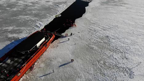 People-Swim-Behind-Icebreaker-Ship-At-Wintertime-In-Lapland,-Finland