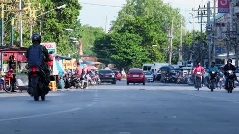 Street-scenario-of-street-vendors,-cars,-motorcycles,-a-tourist-attraction-of-an-authentic-cultural-lifestyle-with-roadside-hawkers-and-street-food-in-Lopburi-in-Thailand