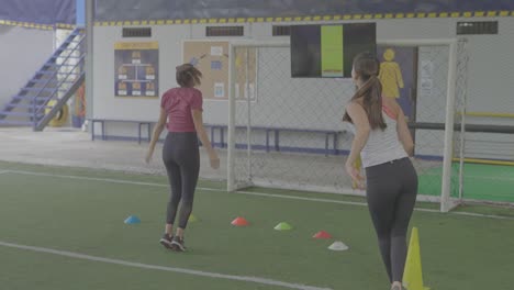 Mädchen-Trainieren-Auf-Fußballplatz-Mit-Hüpfkegeln