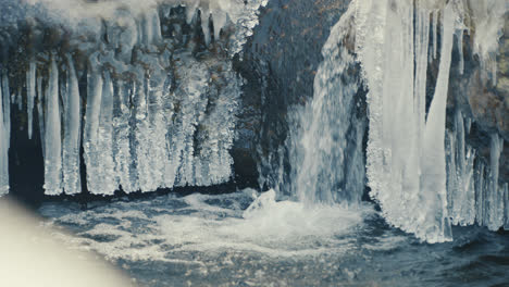 Kleiner-Wasserfall-Eines-Zugefrorenen-Flusses-Im-Winter,-Weitwinkelaufnahme,-Zeitlupe,-Handheld