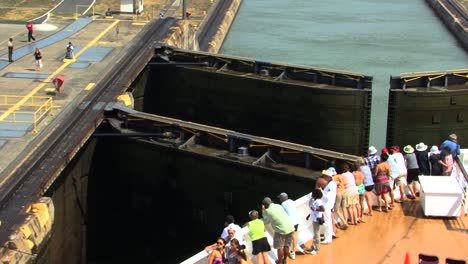 Tourists-on-the-bow-of-a-Cruise-ship-watching-the-transit-process-of-Miraflores-Locks,-Panama-Canal