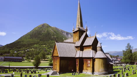 Exterior-View-Of-Stave-Church-With-Gravestone-On-A-Sunny-Summer-Day-In-Norway
