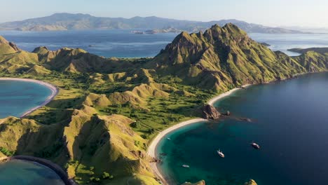 Panorama-of-Padar-island-Indonesia-with-tour-boats-below-and-Komodo-in-the-background,-Aerial-pan-right-shot
