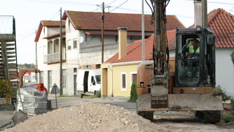 Baggerladermaschine-Bewegt-Sich-Während-Straßenarbeiten-In-Einem-Dorf-In-Leiria,-Portugal,-In-Richtung-Kieshaufen