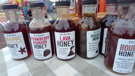 Slow-pan-of-a-vendor's-favor-infused-honey-on-displayed-at-The-Falls-Farmers-Market