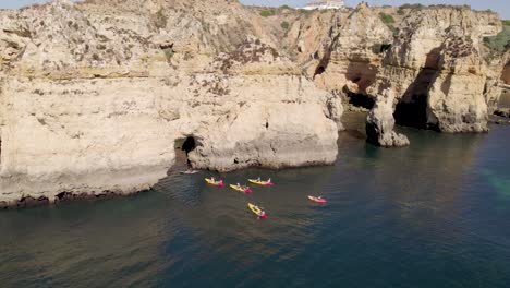 Group-of-people-on-kayak-explore-sea-caves-and-cliffs-of-Ponta-da-Piedade,-Lagos,-Algarve