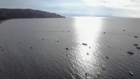 Recreational-boats-in-sun-beam-on-Lake-Titicaca,-world-highest-lake