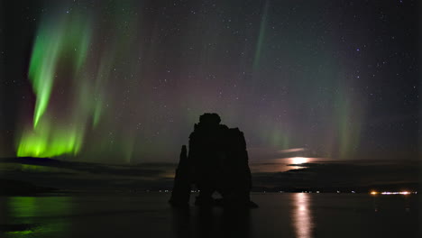 Time-Lapse-of-Northern-Lights-above-Hvítserkur,-Iceland-with-Moonrise