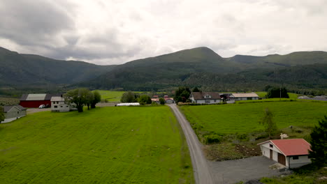 Vista-Aérea-Del-Paisaje-Agrícola-Con-Casas-De-Pueblo-Y-Carretera-En-La-Isla-De-Averoy-En-More-Og-Romsdal,-Noruega