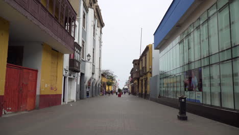 People-walking-on-an-empy-colonial-street-during-covid-times-in-Jiron-Francisco-Pizarro,-Trujillo,-La-Libertad,-Peru