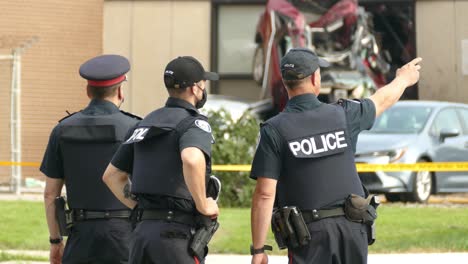 Bewaffnete-Polizisten-Sichern-Parameter-Eines-Autounfalls-In-Toronto,-Kanada