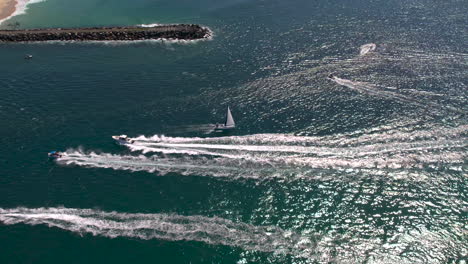 Vista-Aérea-De-Drones-Rastreando-Un-Yate-Navegando-Hacia-El-Mar-A-Través-De-La-Vía-Marítima-Evitando-Otros-Barcos-En-Un-Hermoso-Día-En-El-Spit-Gold-Coast-Qld-Australia
