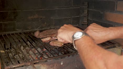 Hands-cutting-with-knife-and-fork-meat-on-barbecue