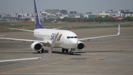 Skymark-Boeing-737-800-Maniobrando-En-La-Plataforma-Del-Aeropuerto-De-Haneda-En-Un-Día-Soleado-En-Tokio,-Japón