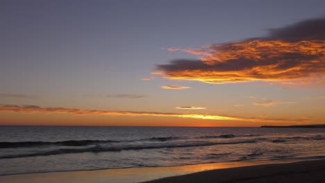 Sunrise-skies-over-calm-ocean-waves-at-dawn,-mediterranean-sea,-spain
