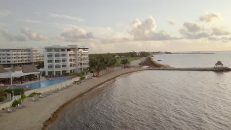 Luftaufnahme---Hotel,-Schwimmbad-Und-Eine-Kleine-Bucht-In-Cancun,-Mexiko,-Vorwärtsaufnahme