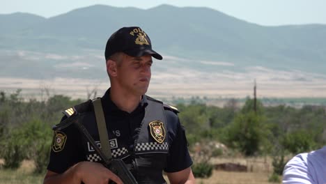 Azerbaijani-Police-stand-guard-with-an-AK47-during-a-tour-of-Agdam-in-Nagorno-Karabakh,-Azerbaijan