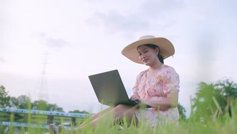 Young-Asian-woman-using-notebook-in-external-nature-area