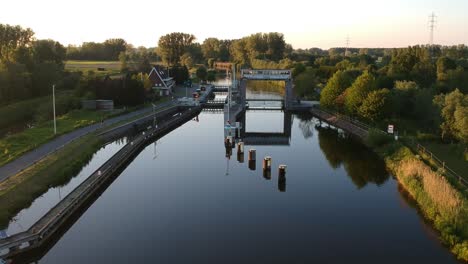 Water-lock-with-trees-reflection-during-golden-hour-in-ascending-drone-view
