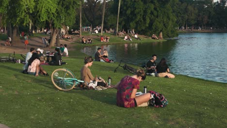 Gente-Relajándose-En-El-Parque-Junto-Al-Lago-En-Un-Hermoso-Día