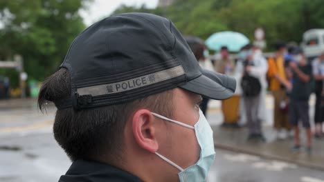 A-police-officer-stands-guard-under-the-rain-as-he-wears-a-face-mask-in-Hong-Kong