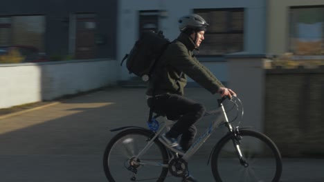 Following-cyclist-traveling-along-road-in-Irish-town