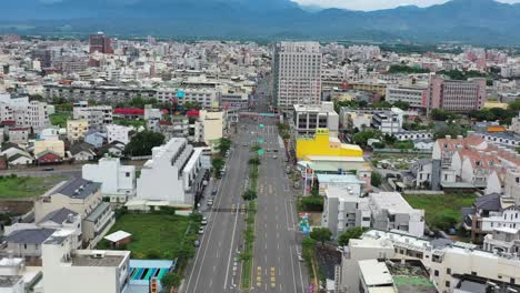 Bird-Eye-View-Aerial-Drone-Footage-flying-straight-with-traffics,-houses,-buildings-and-beautiful-mountain-at-the-background-at-Doliu-City-Taiwan,-True-Asia