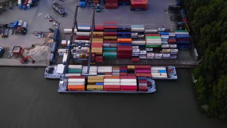 Aerial-Top-Down-View-Of-Gantry-Crane-Moving-Cargo-Containers-At-Loading-Facility
