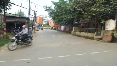 Stadtstraßen-In-Sarnath-Mit-Verkehr-Und-Menschen,-Die-In-Einem-Fahrzeug-In-Indien-Vorbeifahren